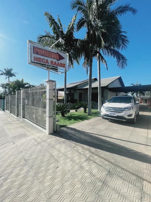 a car parked in front of a motel sign at Pousada Neca Raabe in Pântano Grande