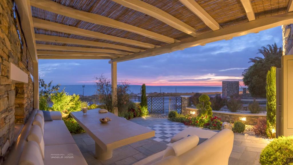 a patio with a table and a view of the ocean at Sunrise Pelion Sea View Villas in Chorefto