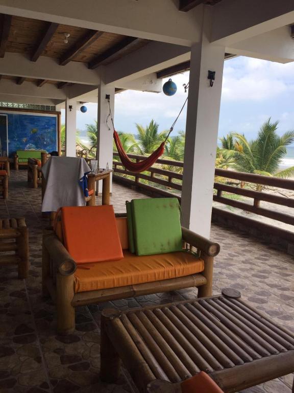 a porch with a bench with colorful bags on it at Renacer de Gaia 888 in Mompiche