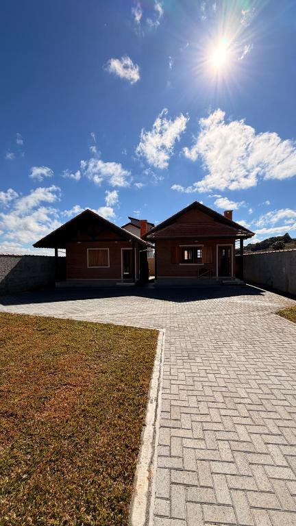 a house with a brick driveway in front of it at Chalés Nascer do Sol in Camanducaia