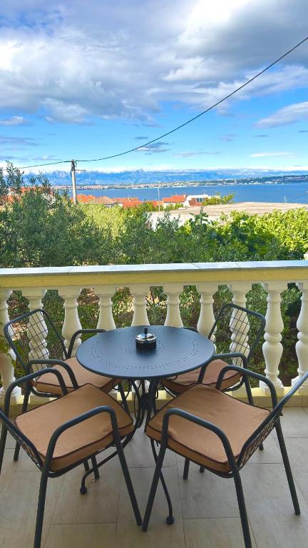 a table and chairs on a balcony with a view at Apartman KALI in Kali
