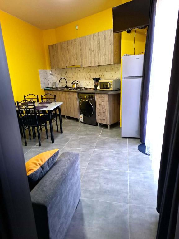a kitchen with a table and a white refrigerator at CityHaven in Ureki