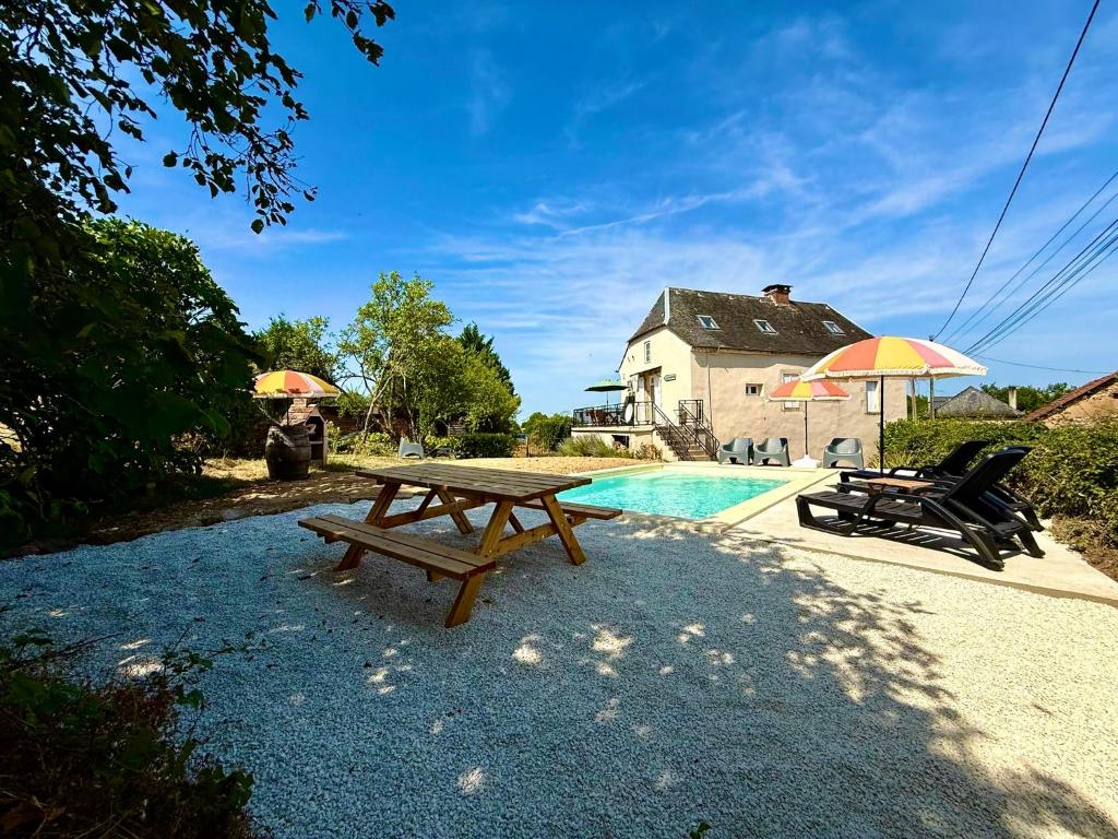a picnic table and two chairs next to a pool at Chez le Cavalier in Génis