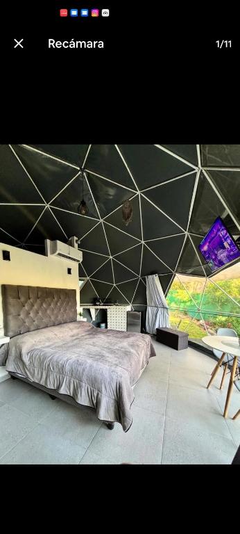a room with a large bed in a tent at Glamping Tlaconal in Oaxtepec