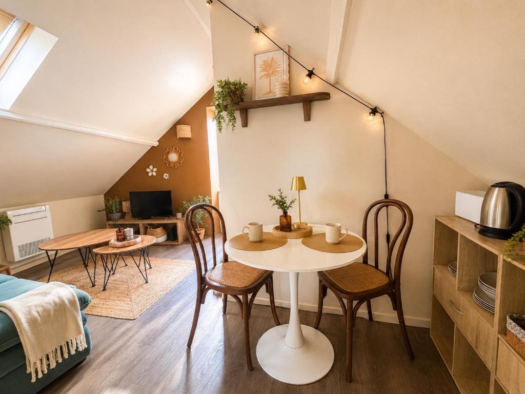 a living room with a table and chairs in a room at La haute république in Brive-la-Gaillarde