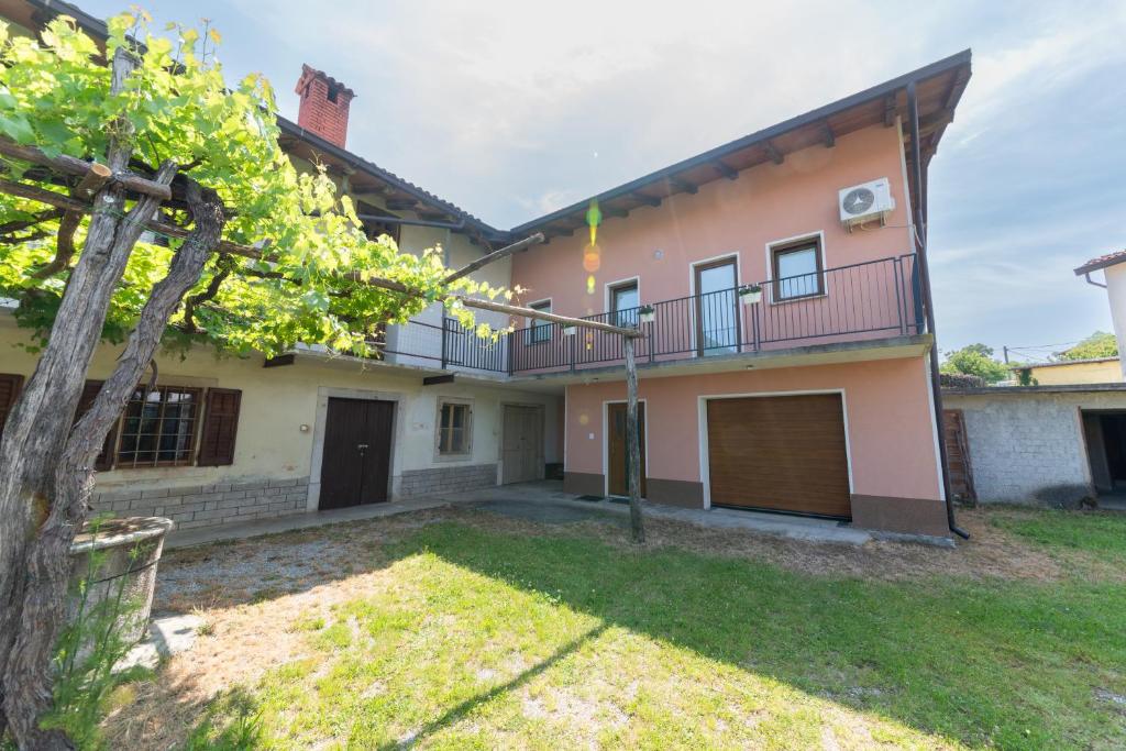 a house with a balcony and a yard at Apartma Luketovi in Vojščica