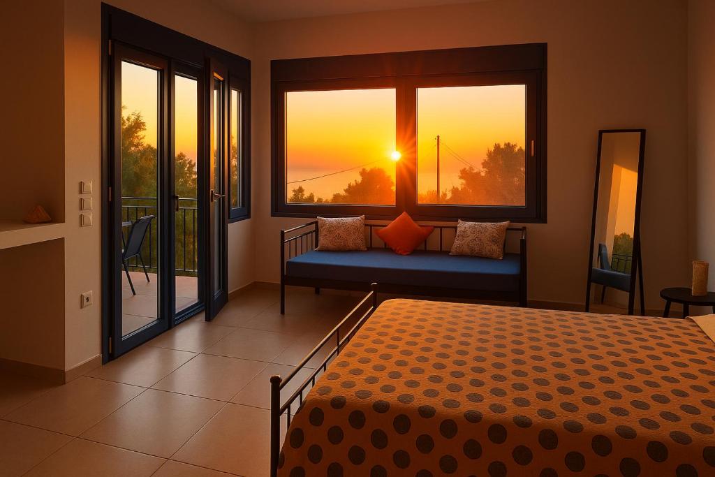 a bedroom with a bed and a window with the sunset at Antigone Salty Studio in Vathí