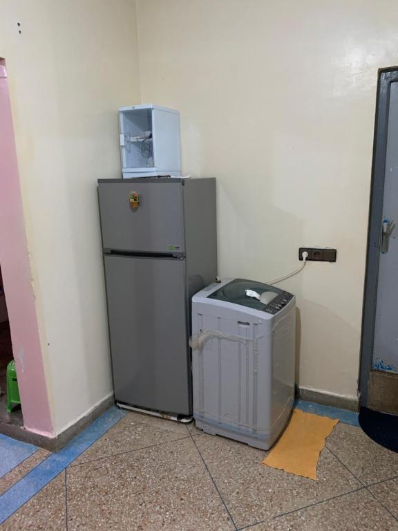 a refrigerator and a trash can in a room at Amzdogh in Sidi Ifni