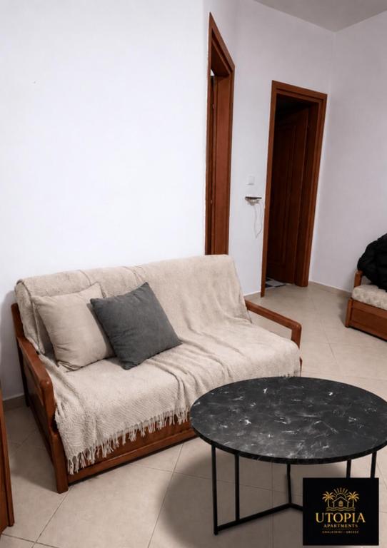a living room with a couch and a table at Utopia Apartment in Kallithea Halkidikis