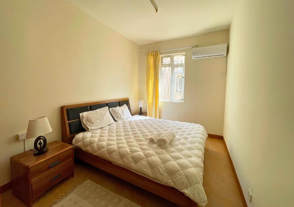 a small bedroom with a bed and a window at Beach Walk Apartment with Private Garden & Wifi in Grand-Baie