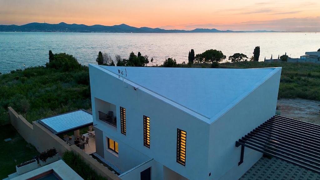 a white building with a view of the water at Villa Marcello in Zadar