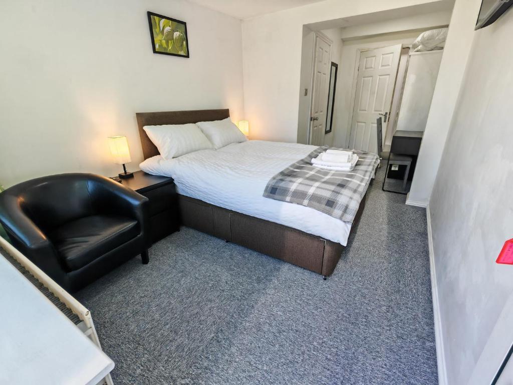 a small bedroom with a bed and a chair at Walnut Studio - Self Contained One-Bed Studio Flat in Oxford