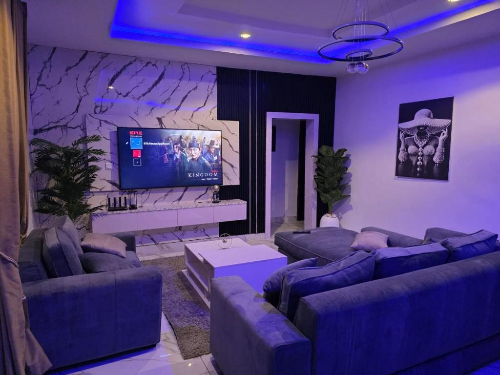 a living room with couches and a flat screen tv at 9th House Apartments in Lagos