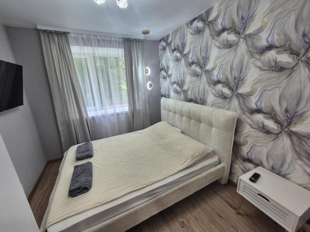 a bedroom with a bed with a flower wall at Like home in Narva