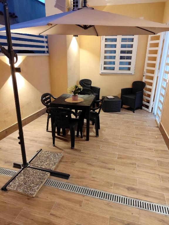 a dining room with a table and chairs and an umbrella at Casa vacanze Carmen House in Ercolano
