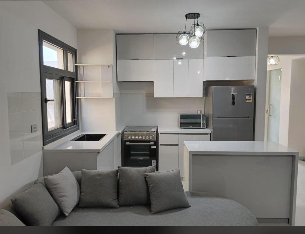 a kitchen with white cabinets and a couch in a room at D-bay north coast 4 bed rooms villa minimum stay 3 nights in Zāwiyat ‘Abd al Mun‘im