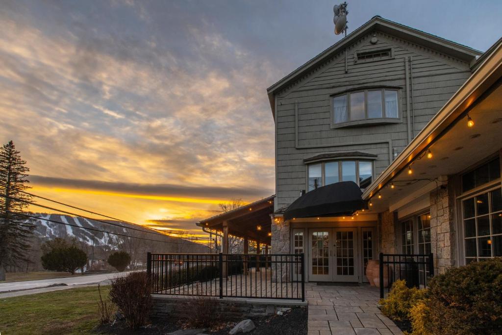 a house with a sunset in the background at The Outpost by Windham Mountain Club in Windham