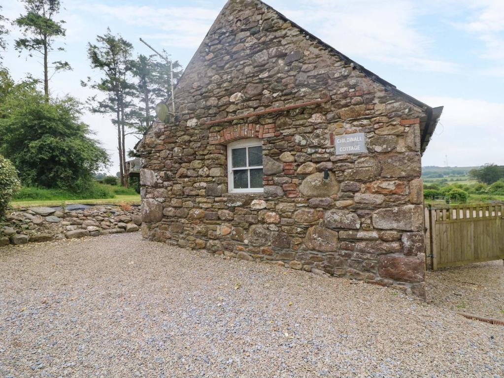 a small stone building with a window on it at Childwall Cottage in Tullagher