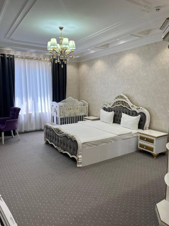 a bedroom with two beds and a chandelier at Suleyman House Premium in Bukhara