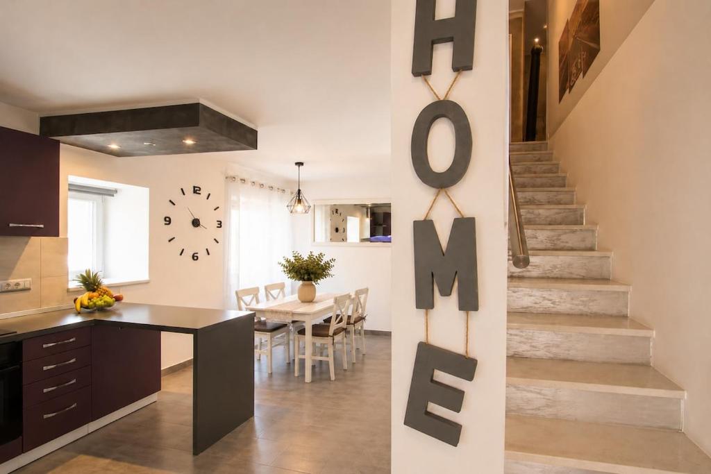a kitchen and dining room with a staircase in a house at App Aurum in Brtonigla