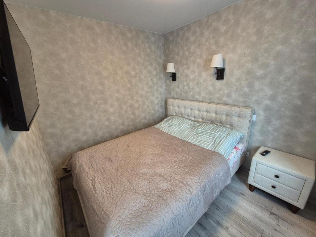 a small bedroom with a bed and a night stand at Apartments near border in Narva