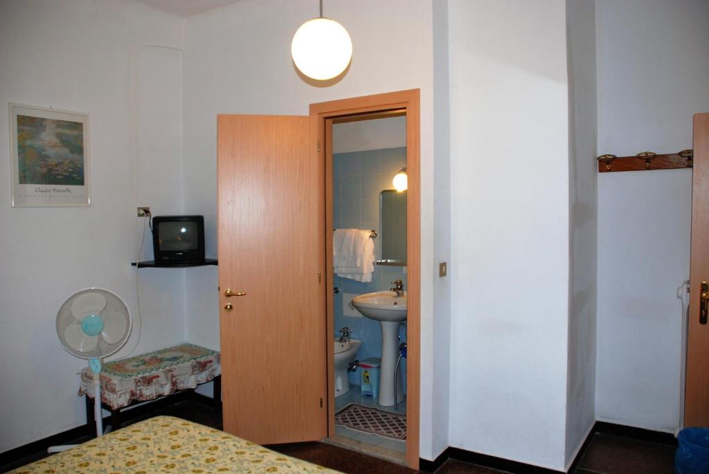 a bathroom with a sink and a toilet and a door at Hotel Major in Genova