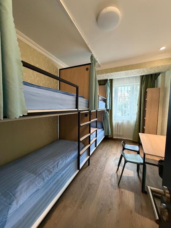 a dorm room with two bunk beds and a desk at Mickey central 2 hostel in Ulaanbaatar