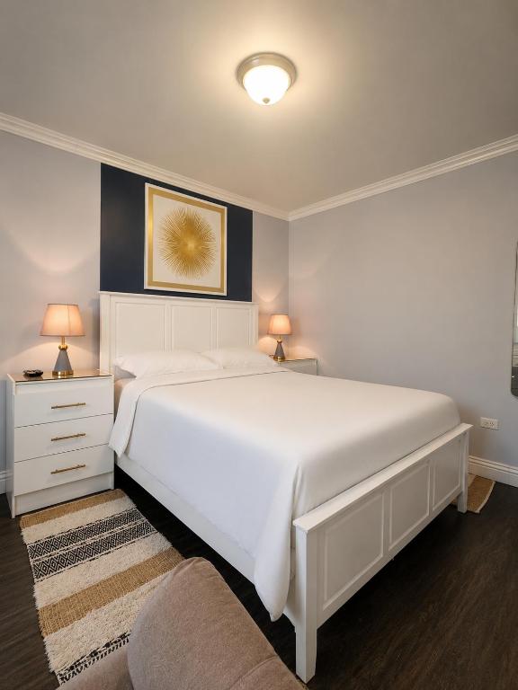 a bedroom with a large white bed and a couch at Inn At Juzani Boutique Hotel in Lambeau
