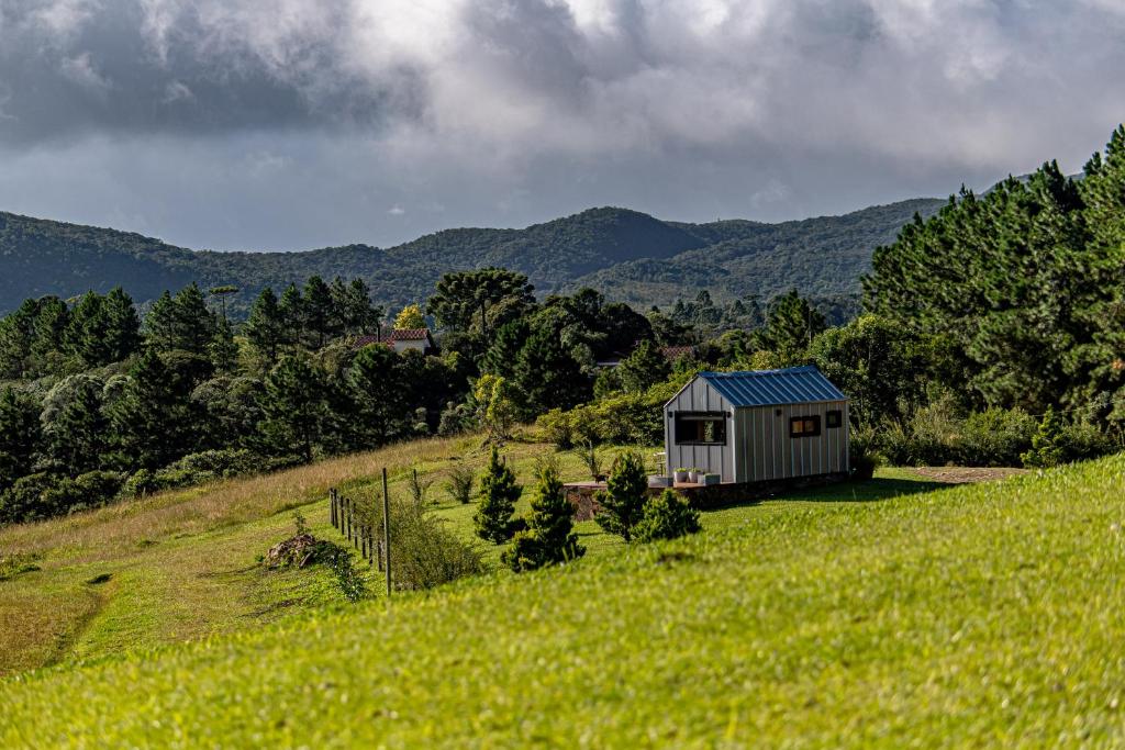 a small house on a hill in a field at Tiny House - Rancho Queimado SC - 15 Min do centro in Rancho Queimado