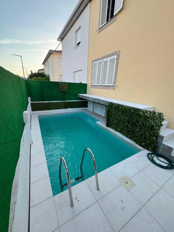 a swimming pool in front of a house at Casa cidade e piscina in Coimbra