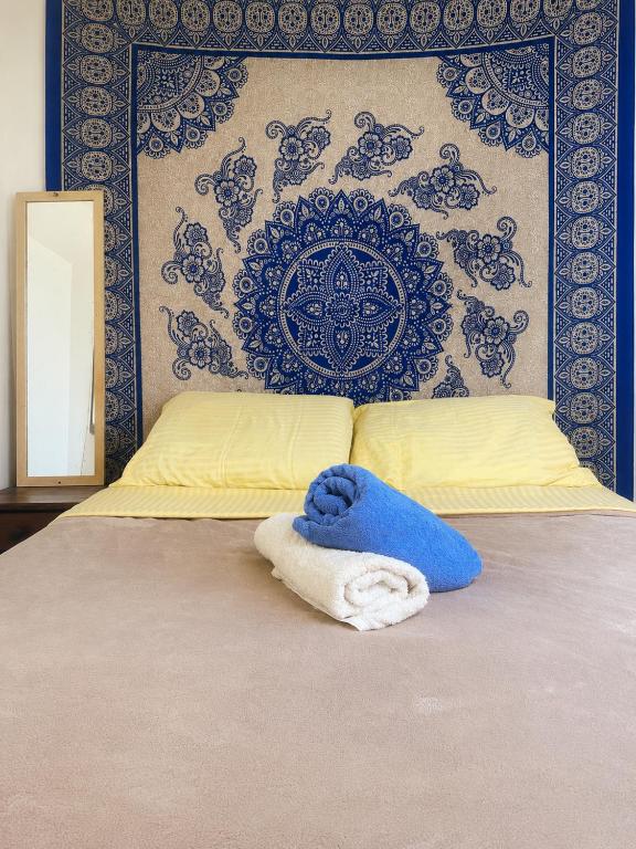 a bed with a blue and white towel on it at Casa da Mata Madalena in Angra dos Reis