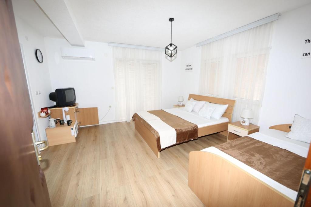 a hotel room with two beds and a tv at Villa Kaya in Ohrid