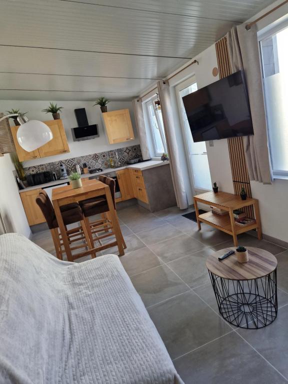 a living room with a couch and a tv and a table at Maisonnette à 350m de la plage in Berck-sur-Mer