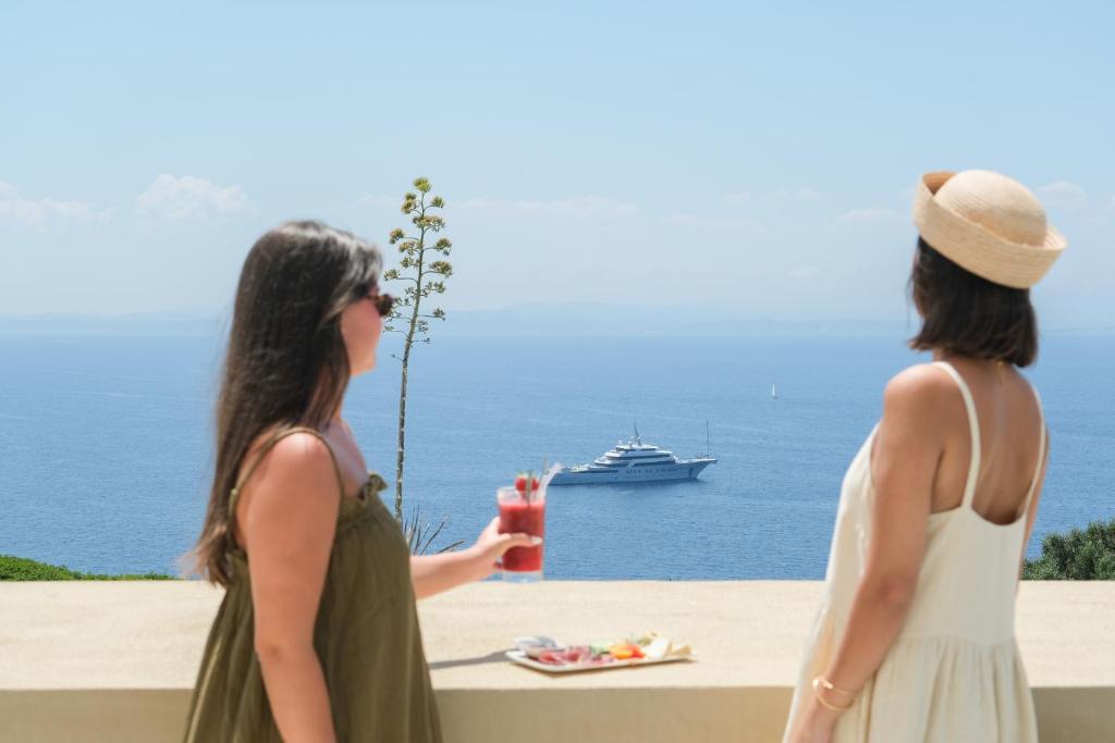 two women standing near the ocean with a cruise ship at Santateresa in Bonifacio