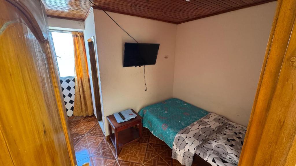 a small bedroom with a bed and a television at Hotel Casaloma in Florián