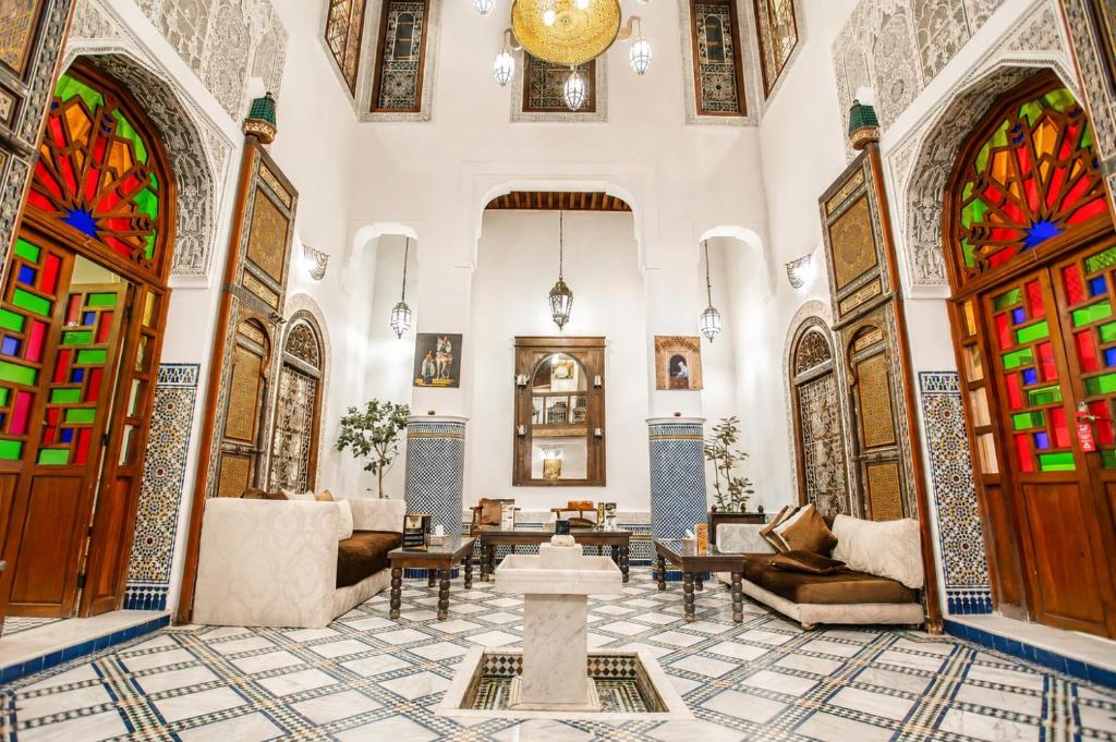 a living room with stained glass doors and furniture at Riad Noujoum Medina Fez in Fez
