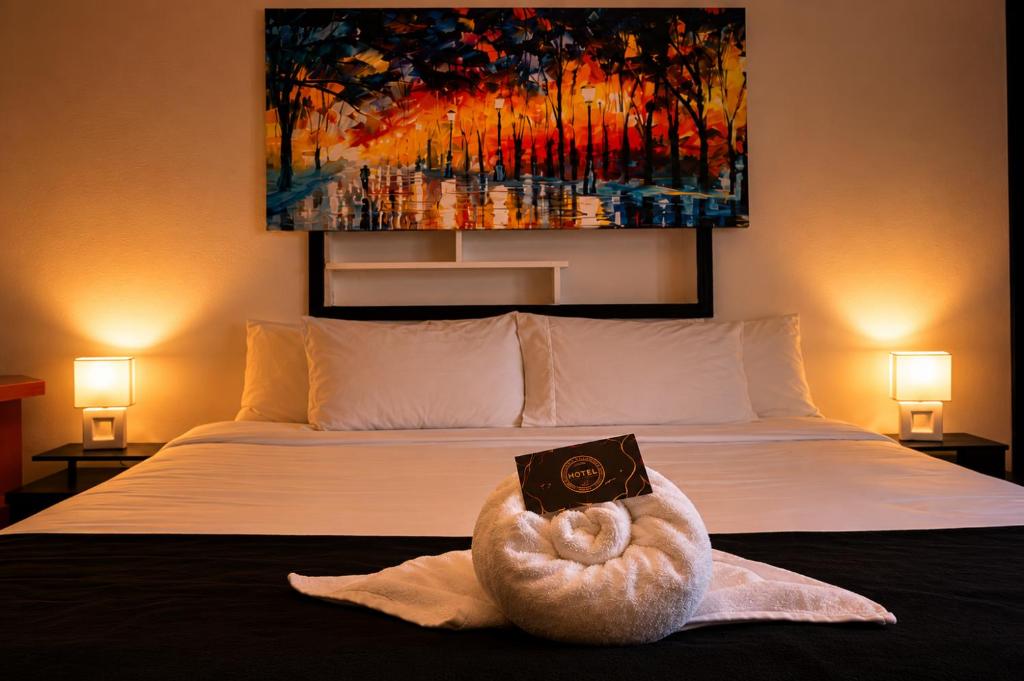 a bedroom with a bed with a book on it at Casa Hotel Estancia Bogota in Bogotá
