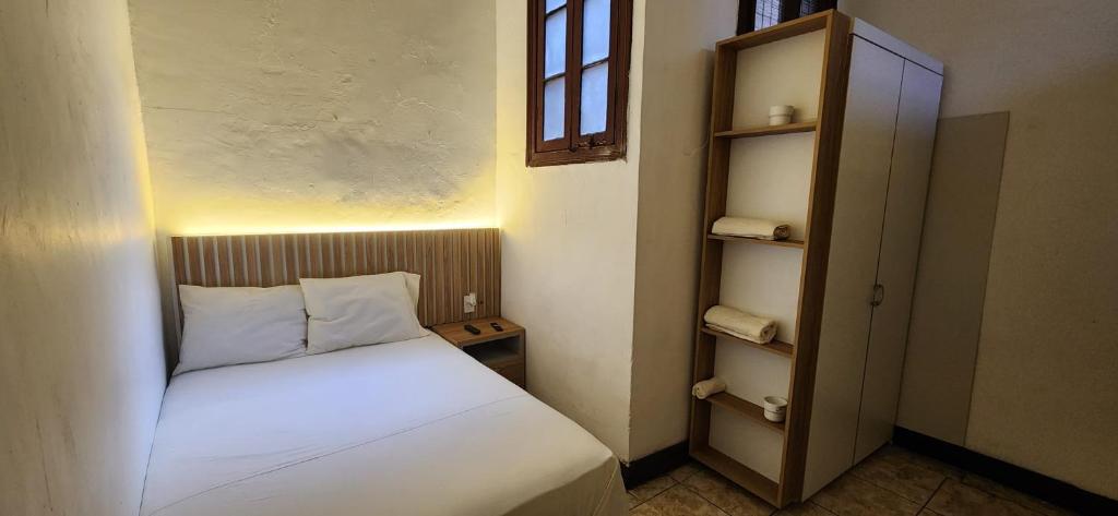 a small bedroom with a white bed and a shelf at Lima Centro Apartment 3 in Lima