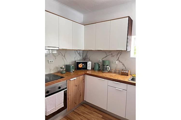 a kitchen with white cabinets and a counter top at O cantinho da Esther in Bustos