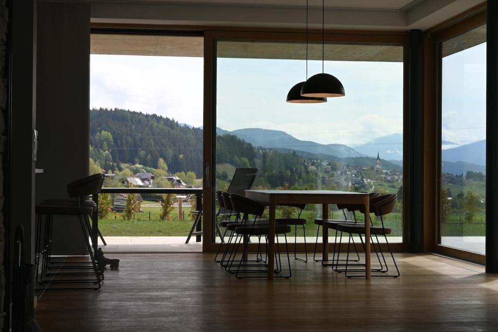 a dining room with a table and chairs and a large window at Haus Preber in Mariapfarr