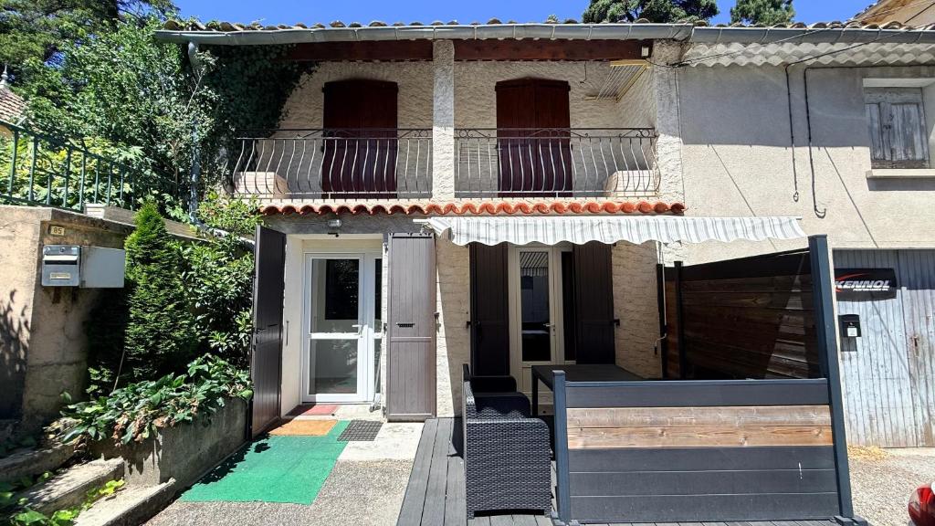 a house with a porch and a balcony with a door at Chez Aneta in Sisteron