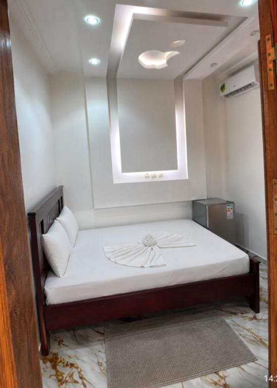 a small room with a bed with a window at Angevita City1 in Edéa