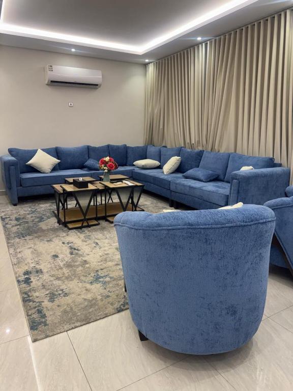 a living room with blue couches and a table at فلل دوبلكس - جدة in Jeddah
