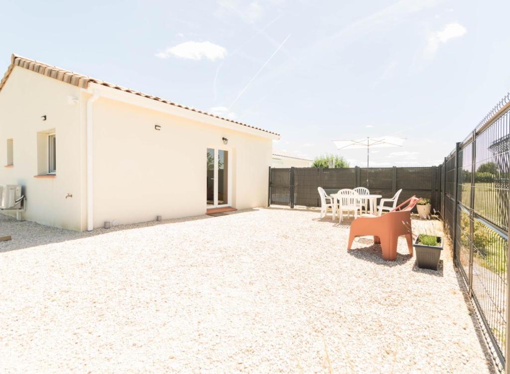 a backyard with a white house and a fence at Maison Lafitte-Vigordane in Lafitte-Vigordanne