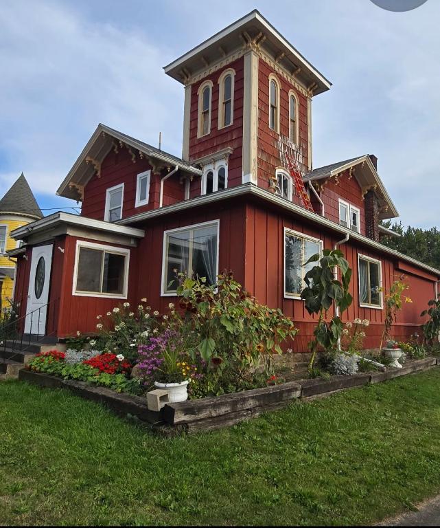 a red house with flowers in front of it at Niagara Historic Inn in Lockport