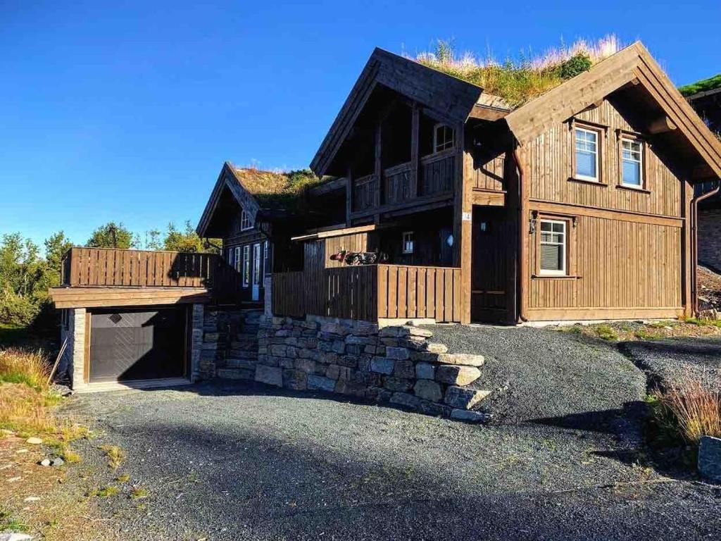 a large wooden house with a grass roof at Ørnereiret in Torvetjørn