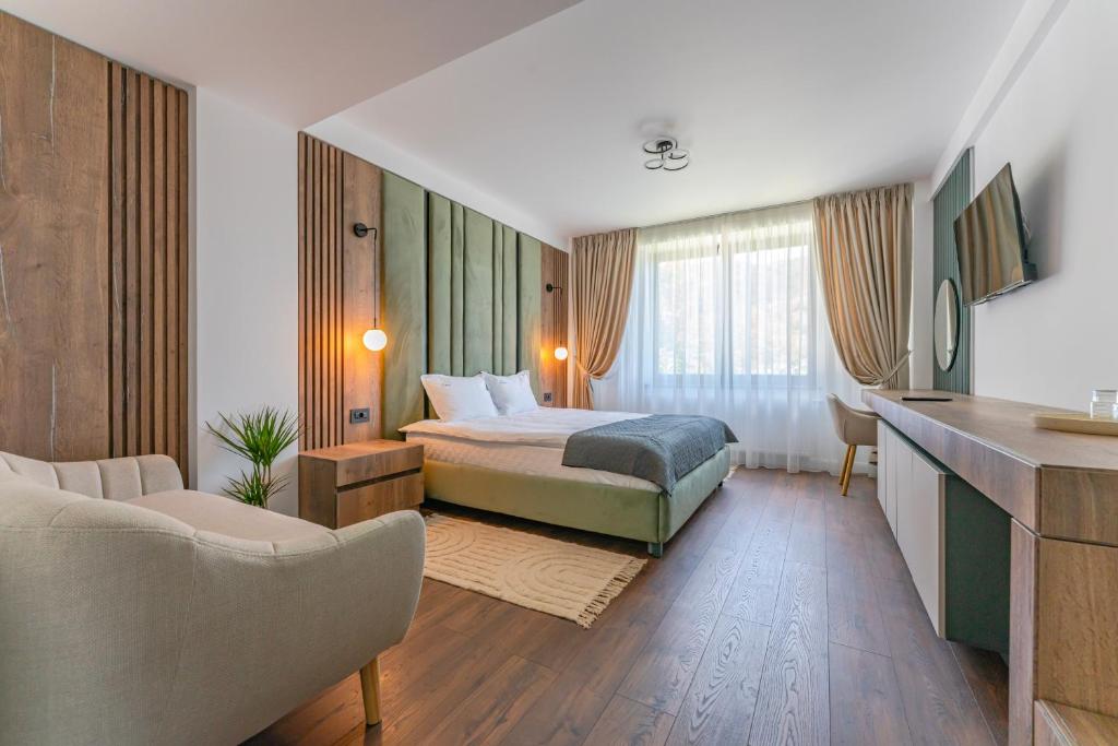 ein Hotelzimmer mit einem Bett und einer Couch in der Unterkunft Vila Core in Rucăr
