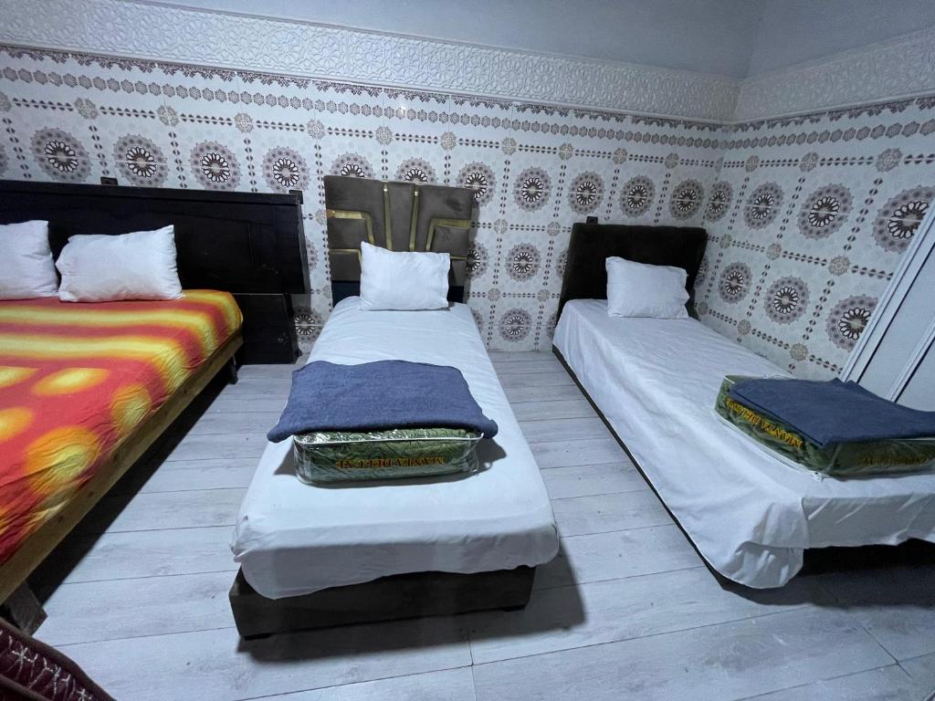 two beds sitting in a room with at Ryad Cherkaoui in Fez