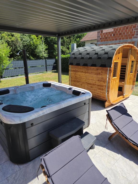 a hot tub sitting on a patio with a gazebo at Kuća za odmor Skela in Glina