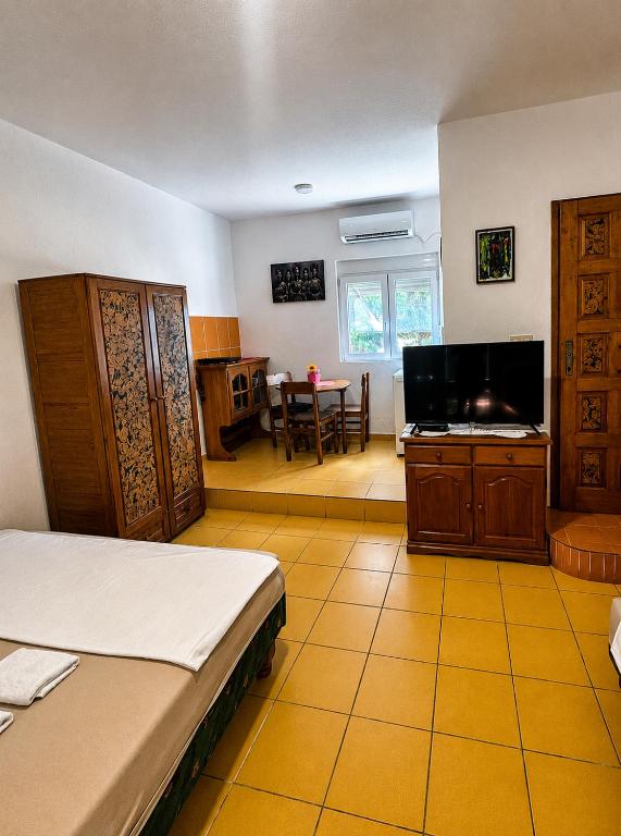 a bedroom with a bed and a flat screen tv at Dodo Obala Apartmani in Sutomore